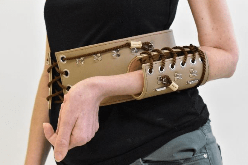 einen modebewussten Gürtel und ein trendiges Korsett zu entwickeln, die den Arm einer Person in Hüfthöhe abstützt