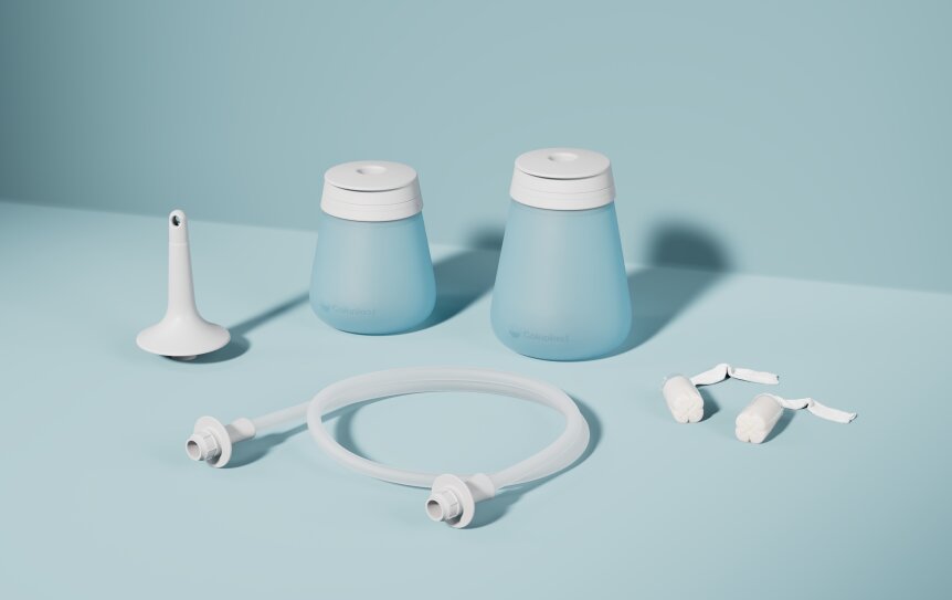 Zwei hellblaue Behälter mit weißen Deckeln, eine weiße Düse, ein flexibler klarer Schlauch mit Verbindungsstücken und zwei kleine weiße Zubehörteile sind auf einem hellblauen Hintergrund angeordnet.